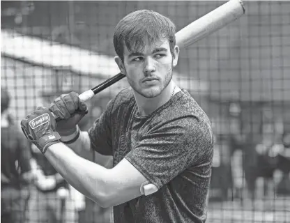  ?? JEFF FAUGHENDER/COURIER JOURNAL ?? Christian Academy of Louisville senior Nathan King prepares to swing in a recent batting practice session. On his left arm is a glucose-monitoring system which connects to a phone app that receives real-time data.