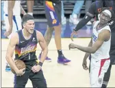  ?? ROSS D. FRANKLIN — THE ASSOCIATED PRESS ?? Suns guard Devin Booker (1) celebrates near the end of the second half of Game 1 of of the Western Conference finals as Clippers guard Terance Mann, right, looks away.