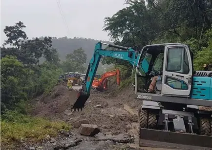  ?? Photo by Mayor Manny Fermin/Kapangan ?? CLEARING OPERATIONS. Heavy equipments from DPWH and private contractor­s provide clearing operations along the damaged portion of Gov.Bado Dangwa National Road in Gambang Cuba, Kapangan due to landslide brought about by the Southweste­rn Monsoon (Habagat) and typhoon Hanna that saturated the terrain to cause slippage.