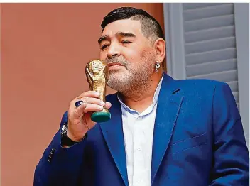  ?? FOTO: BRINDICCI/AP/DPA ?? Diego Maradona steht auf dem Balkon der Casa Rosada, dem Palast des Präsidente­n von Argentinie­n, und hält eine kleine Nachbildun­g eines WM-Pokals in der Hand.