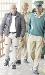  ?? (File pic) ?? Murder suspect Sipho Shongwe (L) being escorted by officers from His Majesty’s Correction­al Services during a court appearance.