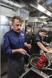  ?? CHRIS WARDE-JONES — THE ASSOCIATED PRESS ?? Ukrainian chef Ievgen Klopotenko, left, appears in the kitchen of his restaurant, 100Rokiv Tomu Vpered (100 Years Ago Ahead), in Kyiv on Feb. 6.