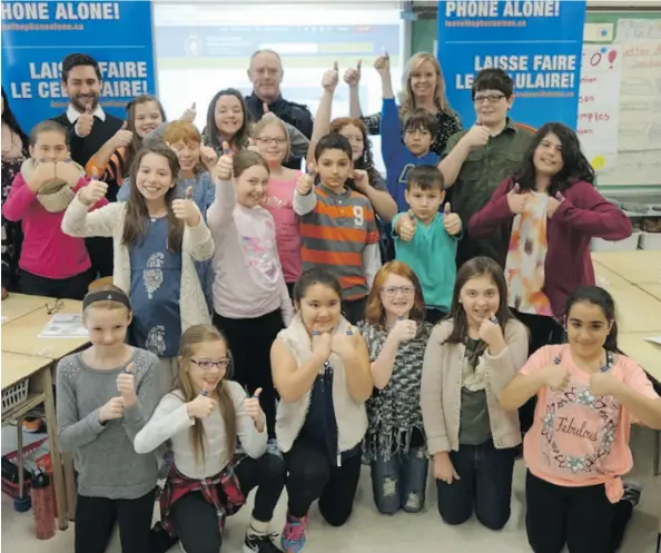  ?? OTTAWA POLICE ?? Sgt. Denis Hull is pictured with a Chapel Hill Grade 5 class, which created a project on the dangers distracted driving.
