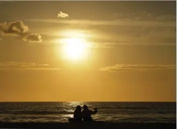  ?? CHRIS DELMAS/GETTY IMAGES ?? People taking selfies while watching a sunset in Manhattan Beach, Calif., are surely not in harm’s way, but as Rosa Silverman writes, our obsession with selfies can be dangerous.