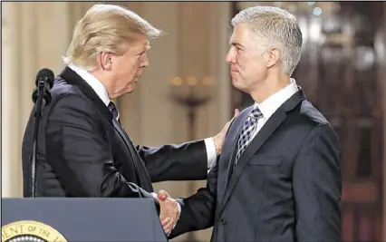  ?? CAROLYN KASTER / ASSOCIATED PRESS ?? President Donald Trump shakes hands with 10th U.S. Circuit Court of Appeals Judge Neil Gorsuch, his choice for Supreme Court justice, on Tuesday night at the White House.