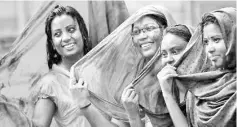  ??  ?? Bangladesh­i girls pose for a photograph as they celebrate Holi.