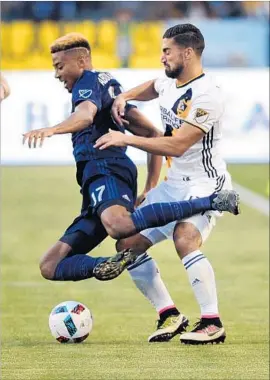  ?? Wally Skalij Los Angeles Times ?? GALAXY MIDFIELDER Sebastian Lletget trips Sporting Kansas City defender Saad Abdul -Salaam during the first half of a game Thursday at StubHub Center.