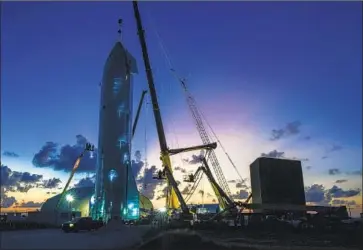  ?? Jonathan Newton Washing ton Post ?? WORKERS put finishing touches on a prototype of SpaceX’s Starship in Brownsvill­e, Texas. Elon Musk, the CEO of SpaceX and the carmaker Tesla, has moved his signature companies from L.A. to the Lone Star State.