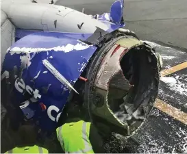  ??  ?? Wrecked: Airport employees inspect the jet’s damaged engine