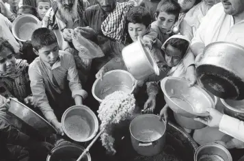  ?? Getty Images ?? Hungry Afghan children scramble for food in 2017, a situation that has gotten worse since the United States withdrew its troops this year.