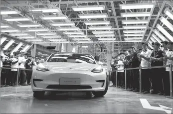  ?? FANG ZHE / XINHUA ?? A Tesla Model 3 car made in China is displayed at the company’s first overseas plant in Shanghai.