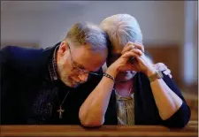  ?? JOE RAEDLE — GETTY IMAGES ?? Rick Jensen and Doris Belanger hug during a memorial at the Holy Family Church on Sunday in Lewiston, Maine. The memorial was held to remember those killed and injured when Robert Card opened fire, killing 18 people in two separate locations on Wednesday night.