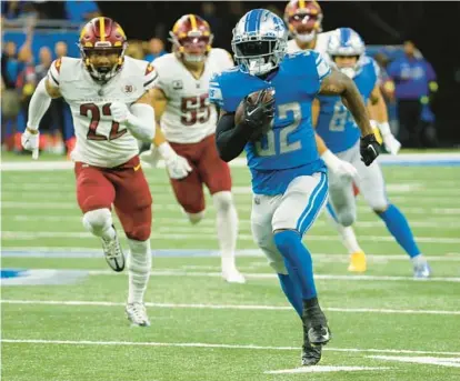  ?? RICK OSENTOSKI/AP ?? Lions running back D’Andre Swift breaks free from the Commanders’ defense during Sunday’s game in Detroit.