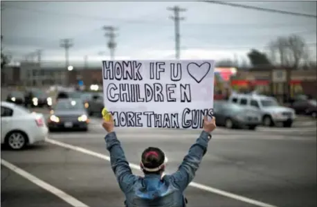  ?? ASSOCIATED PRESS ?? Megan Longstreet holds up a sign as she stands in solidarity with victims of Florida’s Marjory Stoneman Douglas High School shooting on Wednesday in Greensboro, N.C. The group Indivisibl­e Guilford County held the rally to push for new gun control...