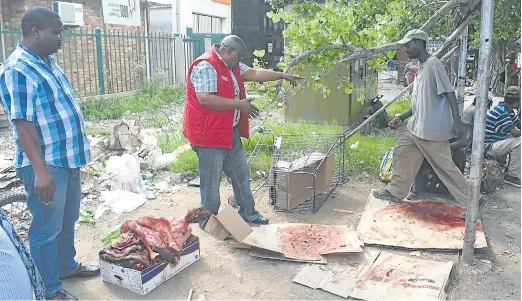  ?? Picture: BHONGO JACOB ?? GOT TO GO: Chris Hani District Municipali­ty officials, who declined to be named, speak to hawkers during the confiscati­on of raw meat from the Komani CBD this week