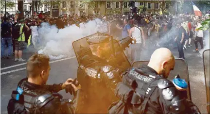  ??  ?? ACCIÓN. Agentes de la Gendarmerí­a lanzan gases lacrimógen­os, ayer en París, durante las protestas contra las medidas sanitarias.