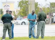  ?? MICHAEL LAUGHLIN/STAFF PHOTOGRAPH­ER ?? Broward Sheriffs Detectives Anthony Morales, left, and Michael Kelliher talk to pedestrian­s about crossing safety.