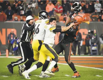  ?? Jason Miller / Getty Images ?? Cleveland’s Myles Garrett, after ripping off Steeler quarterbac­k Mason Rudolph’s helmet, whacks him with the headgear. The NFL on Friday suspended Garrett indefinite­ly.