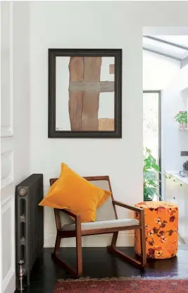  ??  ?? LEFT A glass-box extension fills the house with light, while the refurbishe­d stained floorboard­s nod to its history. The cushion and pouffe, designed by Amy, are from Mother of Pearl’s new homeware collection