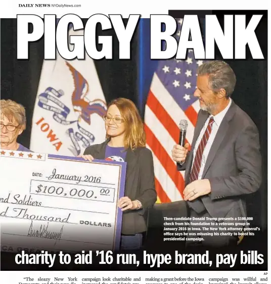  ?? AP ?? Then-candidate Donald Trump presents a $100,000 check from his foundation to a veterans group in January 2016 in Iowa. The New York attorney general's office says he was misusing his charity to boost his presidenti­al campaign.