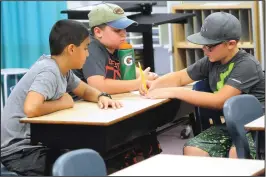  ??  ?? From left, Travis Corediro, Noah Almeida and Brayden Maggio-Seaton, all 10, recall and write down items during observatio­n and recall exercise, part of a Summer Learning and Service program.