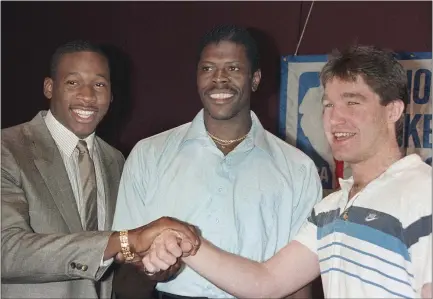  ?? DAVID PICKOFF — THE ASSOCIATED PRESS ?? Future Hall of Famer Patrick Ewing, center, the top overall pick by the New York Knicks in the 1985 NBA draft, is surrounded by Wayman Tisdale, left, who was taken second by the Indiana Pacers, and another future Hall of Famer Chris Mullin, the Warriors’ selection at No. 7.