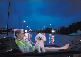  ?? Adrees Latif ?? Reuters A rescue helicopter hovers in the background as an elderly woman and her poodle use an air mattress to float above flood waters from Tropical Storm Harvey while waiting to be rescued Sunday in Houston.