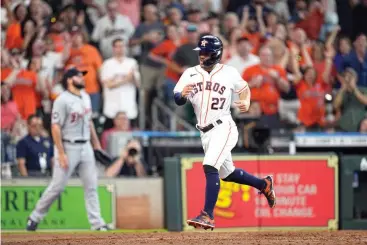  ?? AP Photo/david J. Phillip ?? ■ Houston Astros' Jose Altuve (27) scores on a triple by Michael Brantley during the eighth inning of a baseball game Saturday against the Detroit Tigers in Houston.