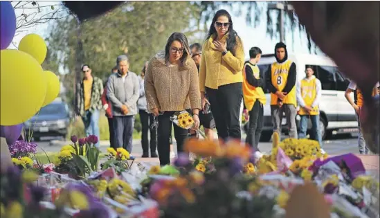  ?? Christina House Los Angeles Times ?? MICHELLE CORDOVA, left, and Azul Cossio pay their respects at a makeshift memorial outside the Mamba Sports Academy on Monday in Thousand Oaks.