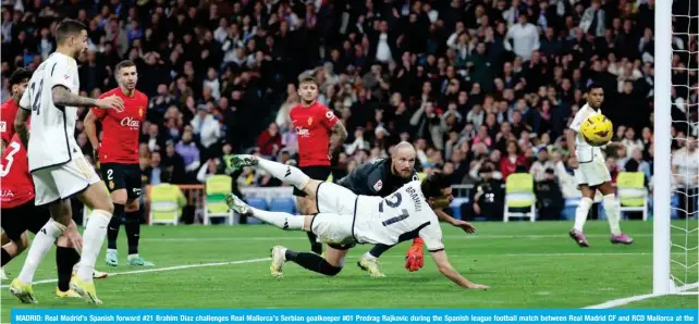  ?? — AFP ?? MADRID: Real Madrid’s Spanish forward #21 Brahim Diaz challenges Real Mallorca’s Serbian goalkeeper #01 Predrag Rajkovic during the Spanish league football match between Real Madrid CF and RCD Mallorca at the Santiago Bernabeu stadium in Madrid.