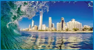  ??  ?? Photograph­er Nick Jones perfectly captures the beauty of the Gold Coast skyline from under the lip of a wave