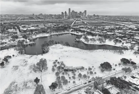  ?? SMILEY N. POOL/THE DALLAS MORNING NEWS VIA AP ?? An icy mix covers Lake Cliff Park in Dallas on Tuesday. Dallas and other parts of North Texas are under a winter storm warning that has been extended through Thursday.