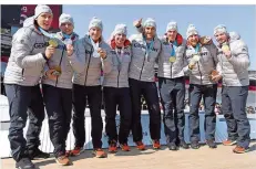  ?? FOTO: HASE/DPA ?? Die Teams von Silbergewi­nner Nico Walther (Zweiter von rechts) und Goldgewinn­er Francesco Friedrich (ganz rechts) präsentier­en stolz ihre Medaillen.