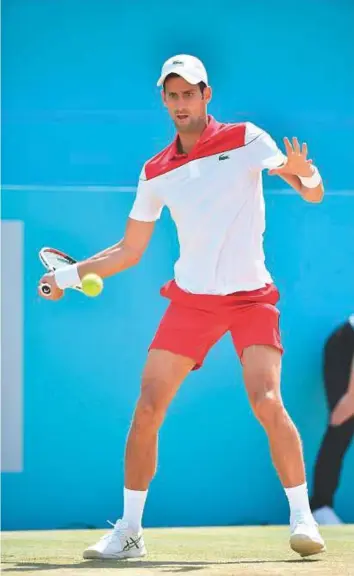  ?? AFP ?? Serbia’s Novak Djokovic returns to Croatia’s Marin Cilic during the men’s singles final at the Queen’s Club Championsh­ips in west London on Sunday.