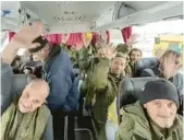  ?? RUSSIAN DEFENSE MINISTRY PRESS SERVICE ?? Russian soldiers wave after they were released Saturday in a prisoner swap with Ukraine. Russia said that 63 of its soldiers were returned.