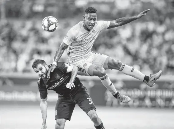  ?? Steve Gonzales / Staff photograph­er ?? Forward Romell Quioto, who had the lone Dynamo goal, goes over the back of Los Angeles FC defender Steven Beitashour to deflect the ball away in the first half.