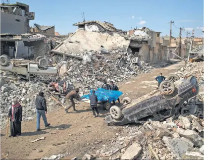  ?? FELIPE DANA, AP ?? Residents carry the bodies of several people killed during fighting between Iraqi security forces and the Islamic State extremist group on the western side of Mosul on Friday.