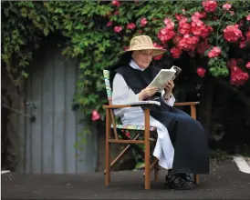  ??  ?? Former Mother Abbess at Glencairn Sr Agnes O’Shea enjoying some well-deserved reading time under the blossoms of the monastic gardens. Sr Agnes, who celebrated her diamond jubilee in 2013, is beloved by all for her gentle demeanour and deep compassion,...