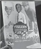  ?? BRIAN JACKSON/AP ?? A mourner holds the program for the funeral of 9-year-old Tyshawn Lee in Chicago on Nov. 10, 2015. Tyshawn’s friend Demetrius Alexander still struggles with it.