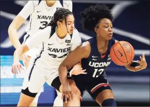  ?? Gary Landers / Associated Press ?? UConn guard Christyn Williams, right, takes control of a loose ball in front of Xavier guard Shaulana Wagner during the first half on Saturday.
