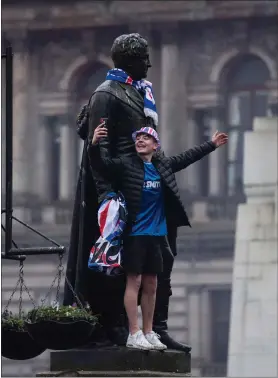  ??  ?? A Rangers fan takes a selfie with a statue in Glasgow’s George Square, where some supporters gathered to celebrate the title win