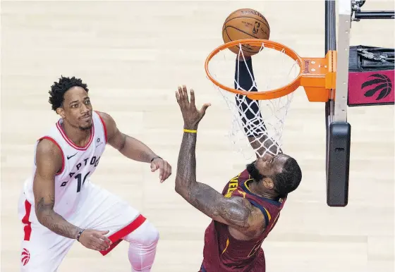  ?? TYLER ANDERSON / NATIONAL POST ?? Toronto’s DeMar DeRozan looks on as Cleveland star LeBron James sinks a basket in the Cavaliers’ victory in Game 2 of their series.