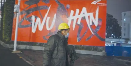  ?? AFP PHOTO ?? A man walks in front of a sign that reads ‘ Wuhan.’ Almost all businesses in the city have reopened two months after a total lockdown due to the spread of the coronaviru­s.
SINGAPORE: