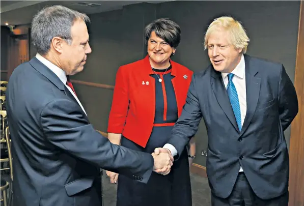  ??  ?? Boris Johnson is greeted at the DUP conference at the Crowne Plaza Hotel, Belfast, by Arlene Foster, the party leader, and Nigel Dodds, her Westminste­r deputy. He urged the DUP’s 10 MPs to work with him to defeat the Brexit deal