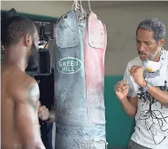  ?? CONTRIBUTE­D PHOTOS ?? Ras Kassa (right) preps the 'champion boxer' during a scene in Roar For A Cause.