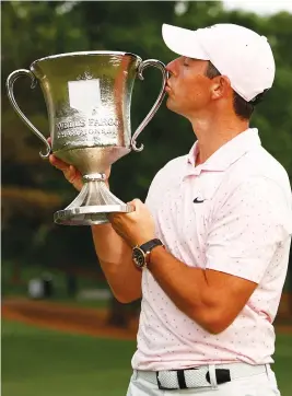  ?? Picture: AFP ?? BACK TO WINNING. Ulsterman Rory McIlroy kisses the trophy after winning the Wells Fargo Championsh­ip at Quail Hollow Club in Charlotte on Sunday.