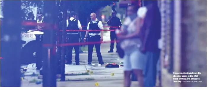  ?? TYLER LARIVIERE/SUN-TIMES ?? Chicago police investigat­e the shooting scene in the 1000 block of West 79th Street on Tuesday.