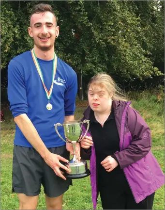  ??  ?? Darragh Browne, Lios Tuathail AC, winner of the Novice mens race being presented with the Freddie Murphy Perpetual Cup by Freddie’s daughter Maura.