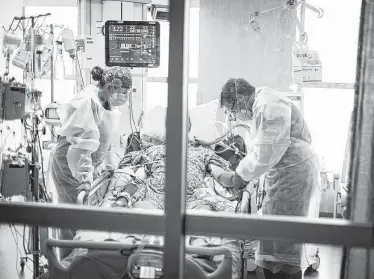  ?? Kyle Green / Associated Press ?? Dr. William Dittrich examines a COVID-19 patient on Aug. 31 at St. Luke’s Boise Medical Center in Idaho as daily deaths surge back to where they were in March.