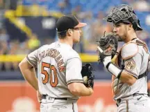  ?? ⅔ ?? Orioles catcher Austin Wynns, right, talks with starting pitcher Bruce Zimmermann during the third inning against the Rays on Sunday in St. Petersburg, Florida. Zimmermann allowed three runs in 5 innings.